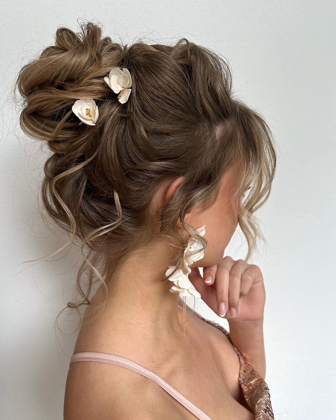 Whimsical Elegance: The Messy High Bun with Floral Accents