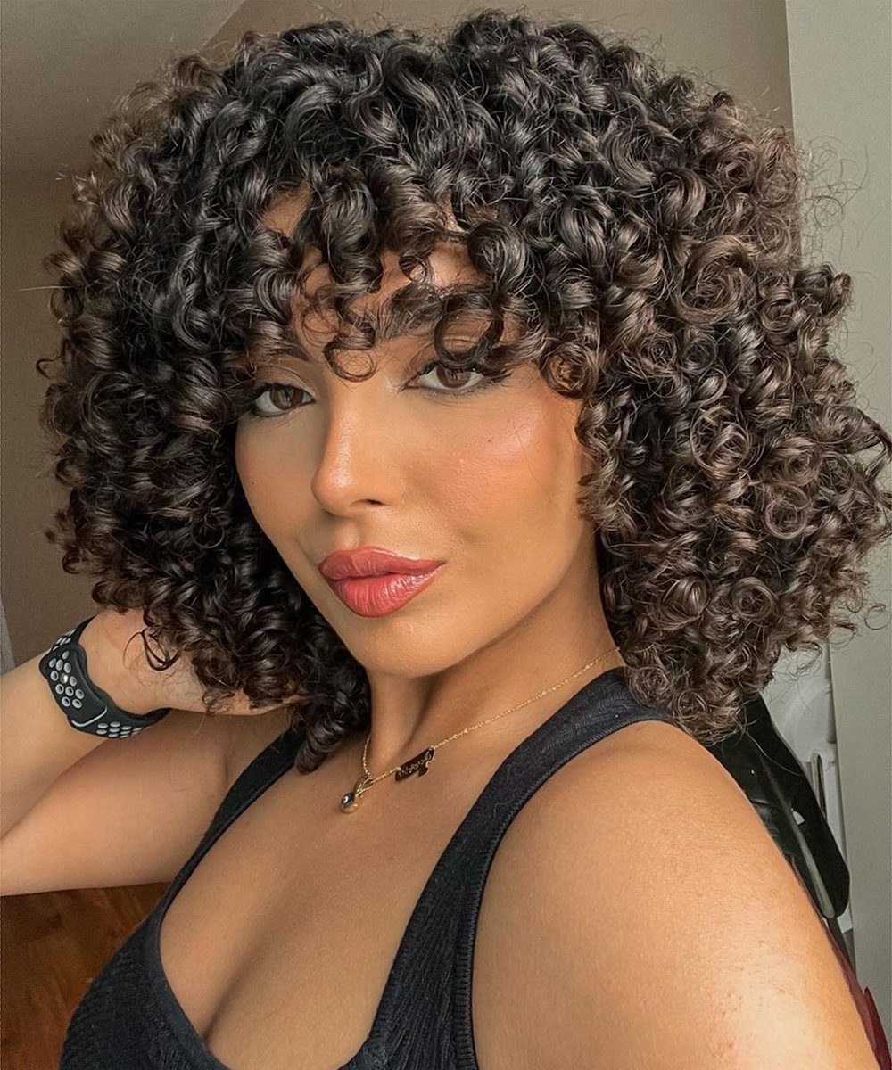 Voluminous Curly Bob With Side-Swept Bangs — Winter Haircuts for Round Faces