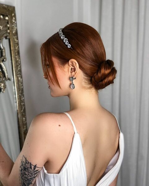 Sleek Red Low Bun With Tiara — Winter Formal Hairstyles