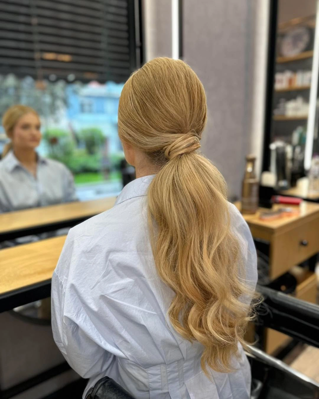 Blonde low ponytail with raised crown and wrapped base
