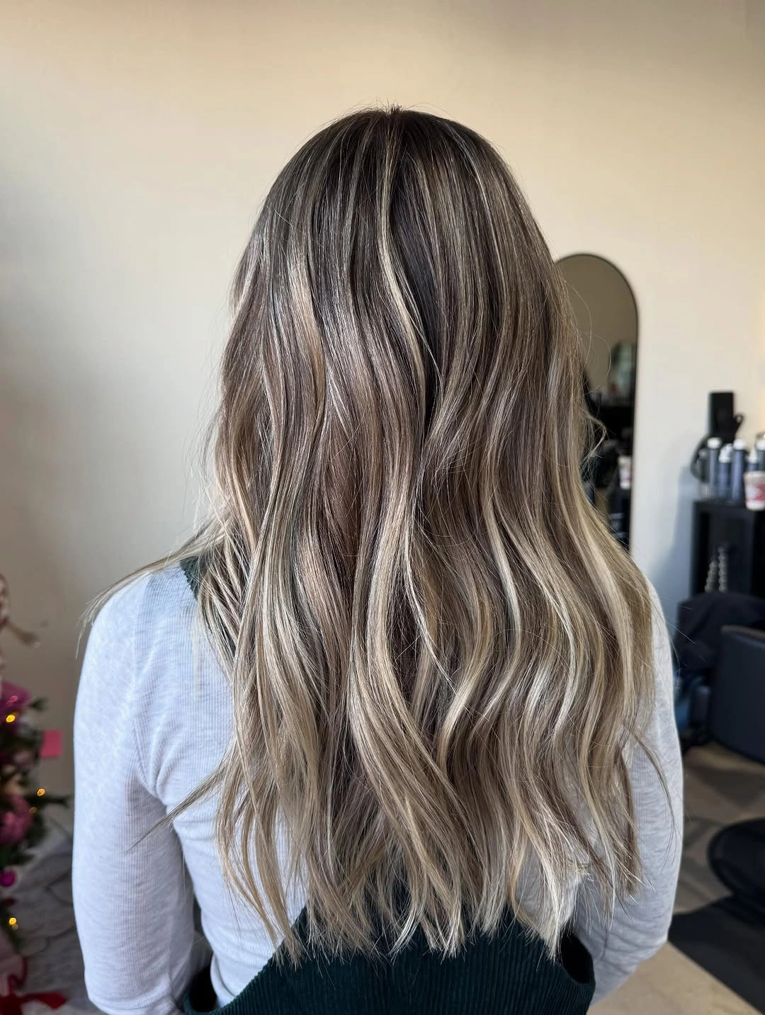 Long brown hair with lighter strands and relaxed lower bends