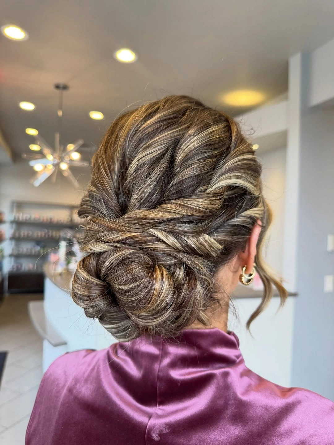 Highlighted low updo with twisted sides and rounded nape loops