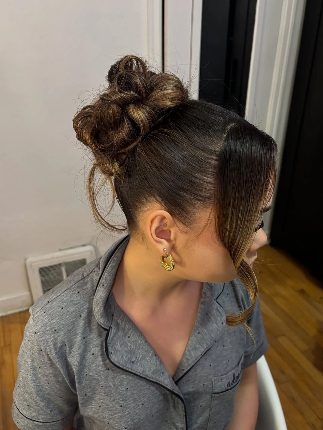 Brown high looped bun with long curved face-framing section