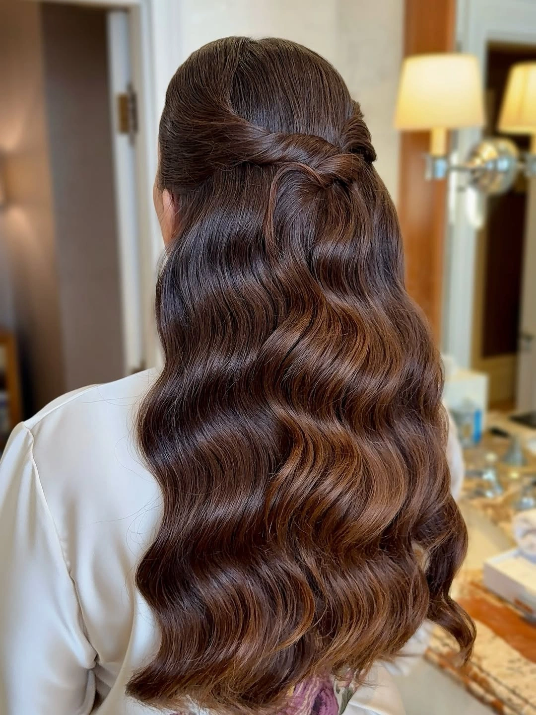 Long brunette half-up hair with broad glossy S-shaped waves