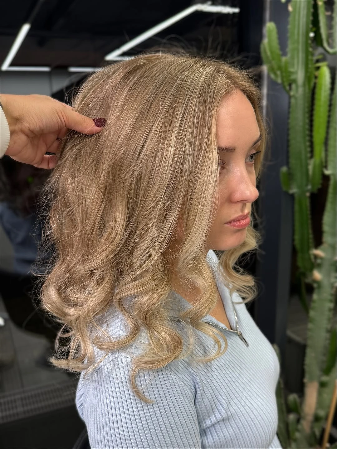 Blonde shoulder-length hair with smooth top and loose curled ends
