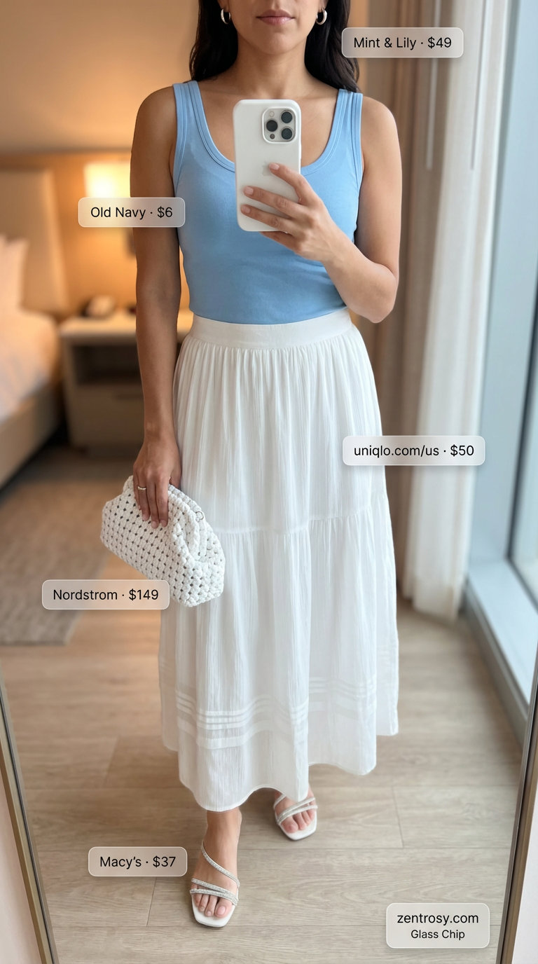 Elegant and relaxed 'Coastal Evening Breeze' casual summer outfit for women 2026 with a flowy sky blue tiered maxi skirt, a white fitted scoop-neck tank top, metallic silver flat sandals, delicate silver hoop earrings, and a woven clutch, perfect for a coastal dinner.
