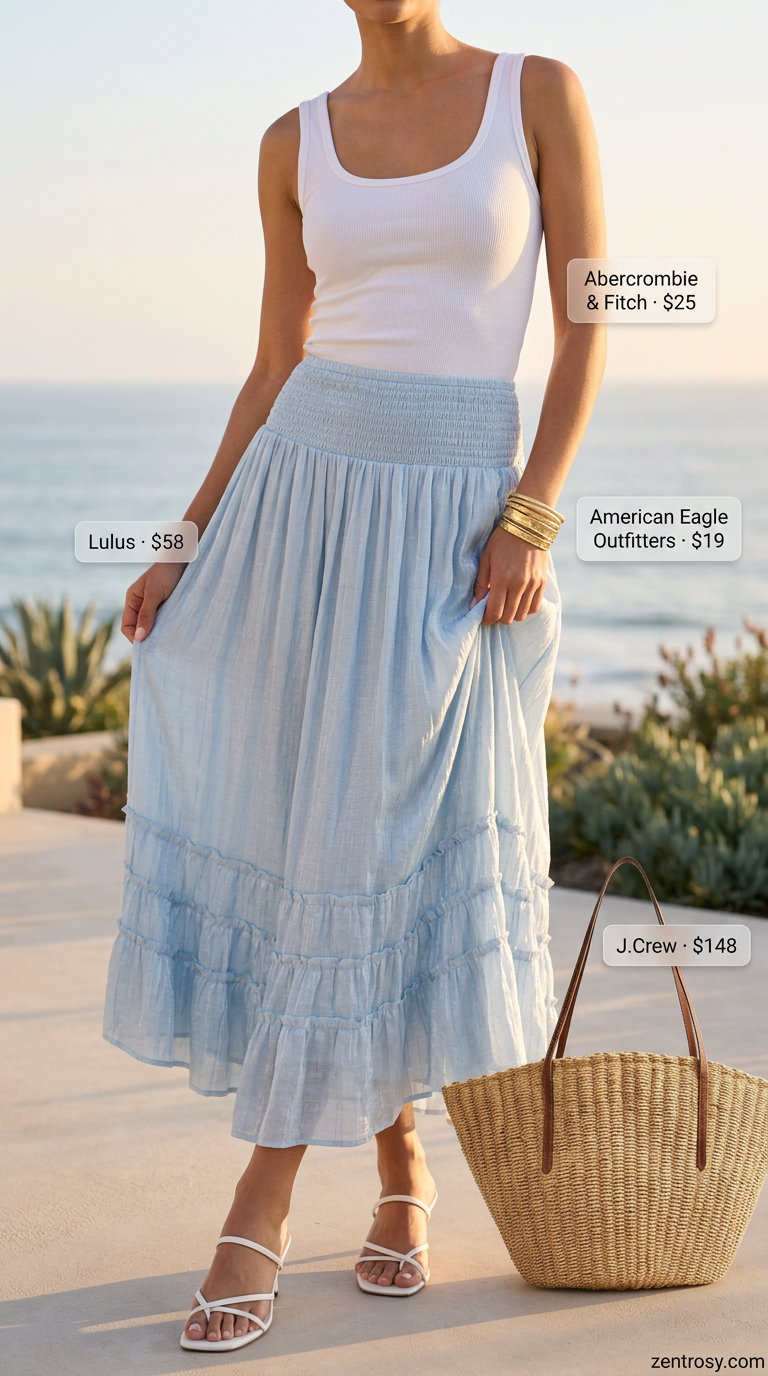 Casual seaside dinner outfit for women 2026. Flowy blue midi skirt with white tank and straw bag.
