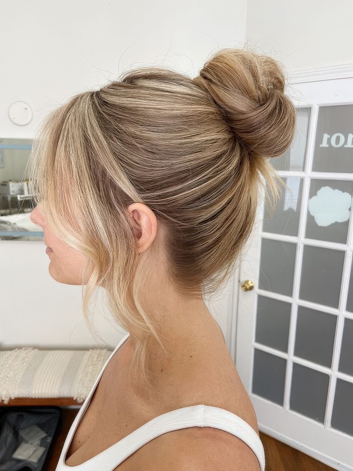 Messy Ash Blonde Bun With Curtain Bangs Messy Ash Blonde Bun With Curtain Bangs — Classy Bun and Bang