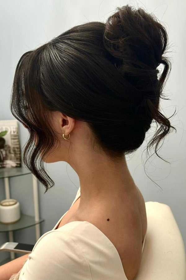 Voluminous Dark Brown High Bun With Loose Tendrils Voluminous Dark Brown High Bun With Loose Tendrils — Classy Bun and Bang