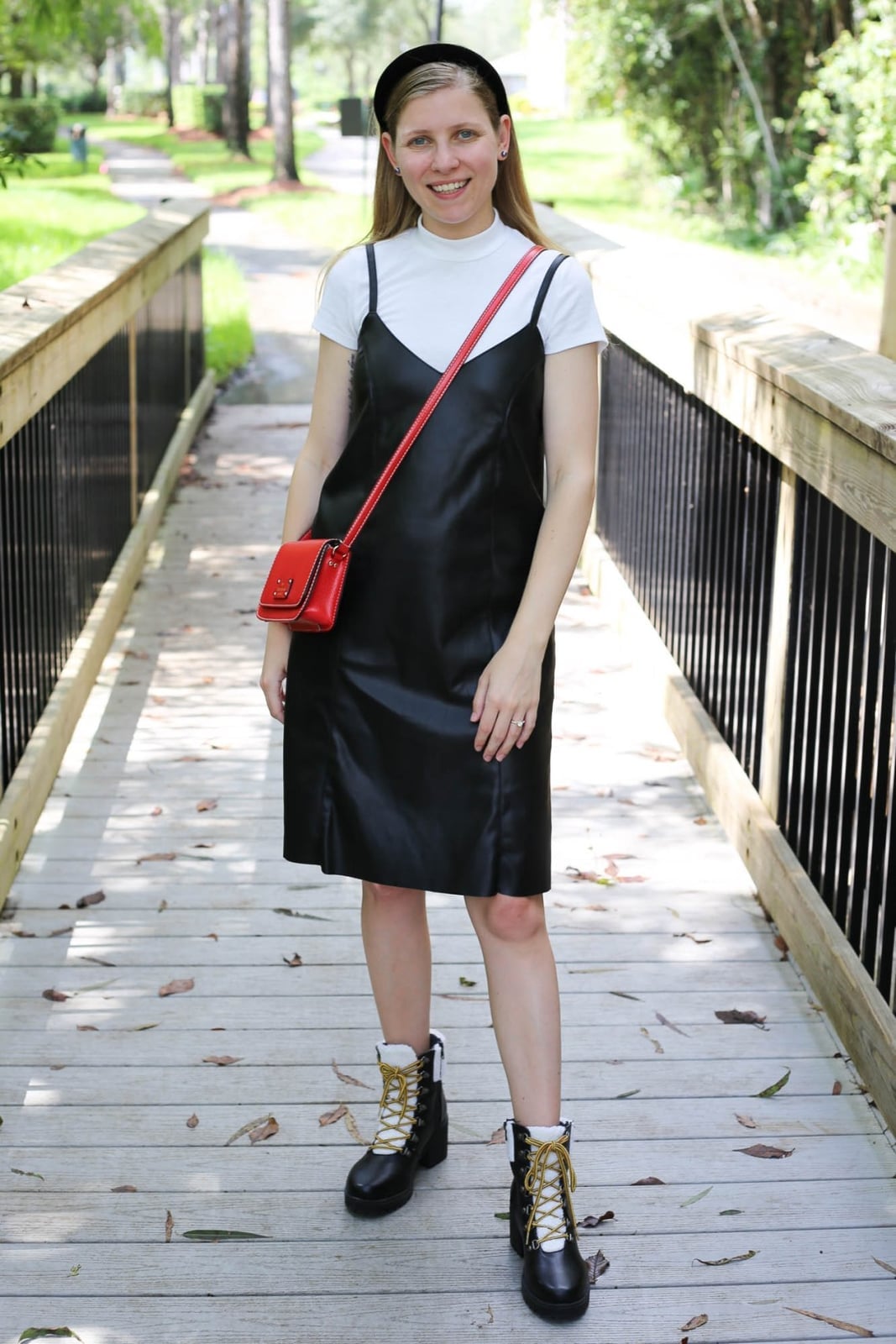 Black Leather Dress Over White T-shirt With A Small Red Crossbody Bag — Classy Layering Dress