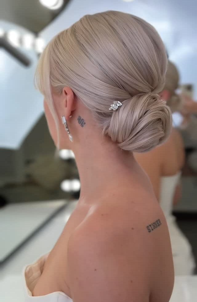 Icy Pearl Blonde Low Bun With Curtain Bangs — Classy Low Bun Wedding Hair