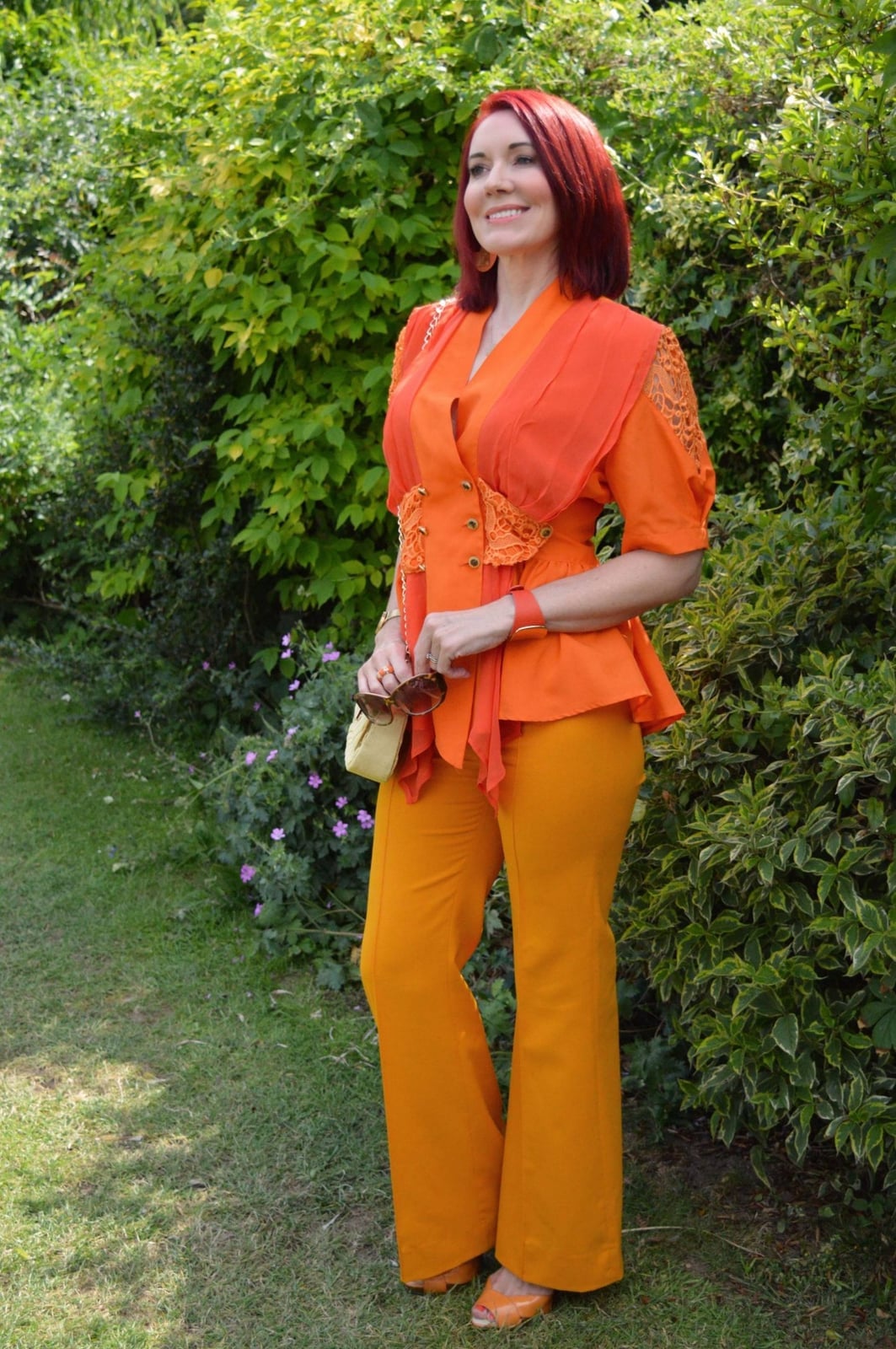 Bright Orange Flared Trousers with a Draped Wrap Top, Close-Up Take — Classy Orange Pants Outfits
