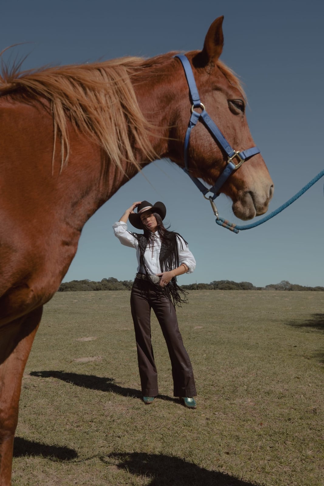 Fringed Vest with Flared Jeans and Metallic Boots and Black Cowboy Hat — Classy Rodeo Outfits for Women