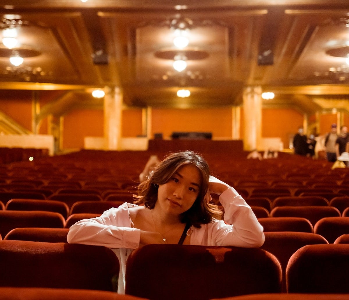 Light Pink Cardigan Over White Top in Theater — Classy Theater Outfits