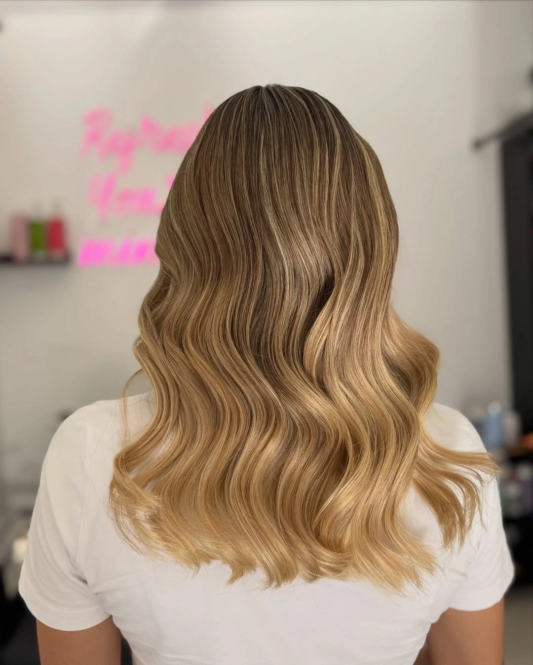 Long honey golden blonde waves with deeper roots and warm golden lengths
