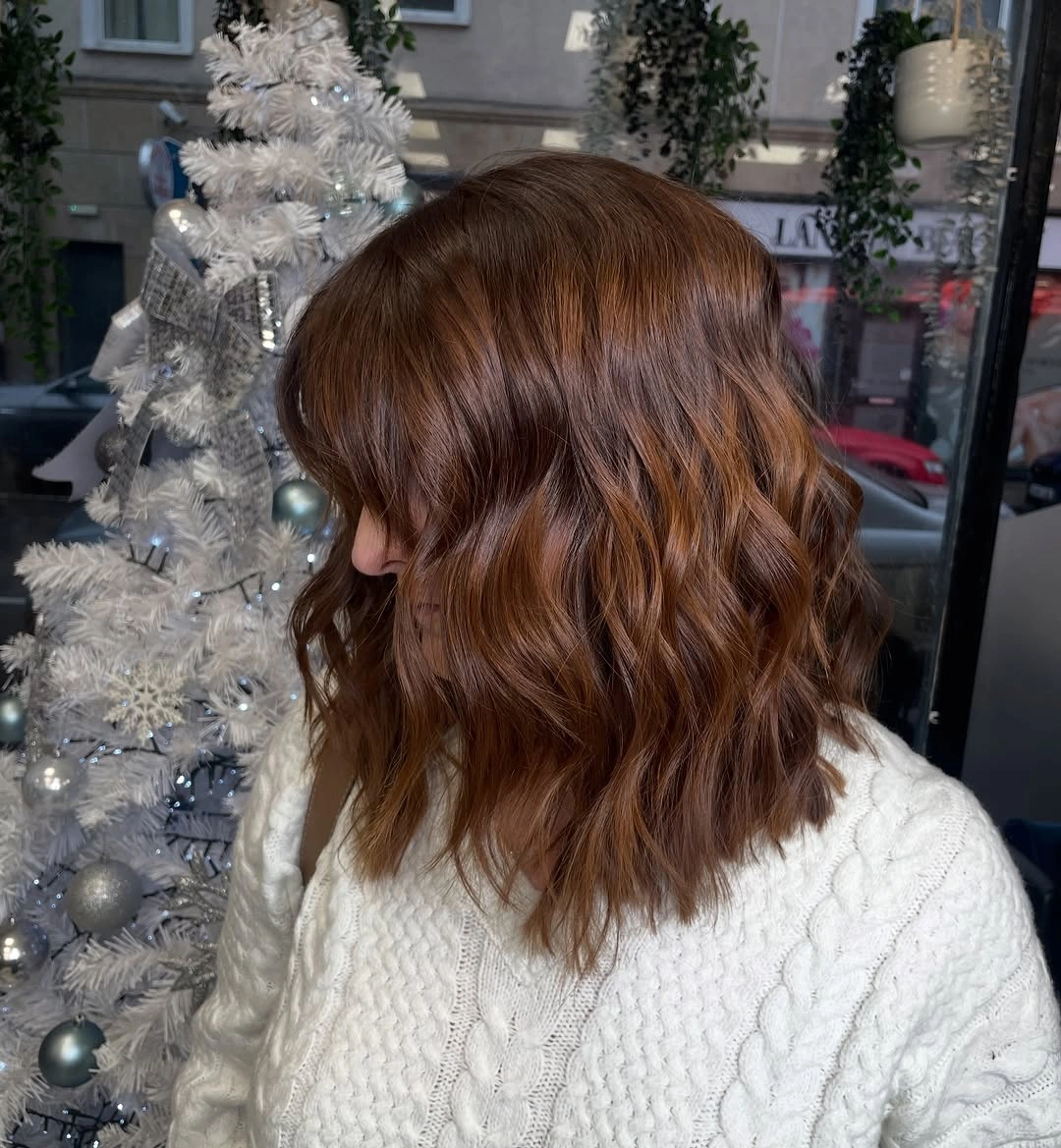 Shoulder-length auburn copper waves with reddish brown tones and textured ends