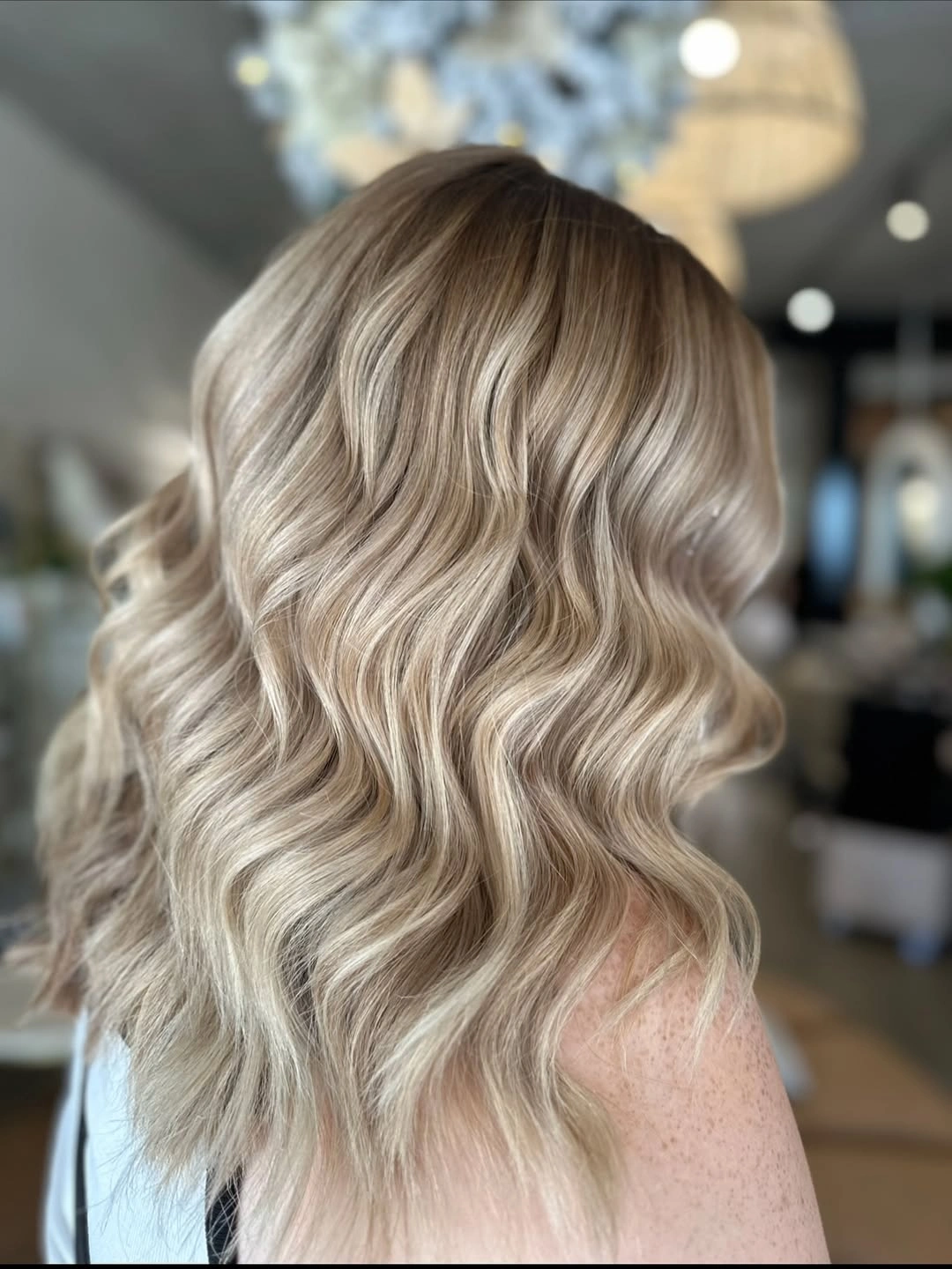 Long light beige blonde waves with slightly darker roots and creamy lengths