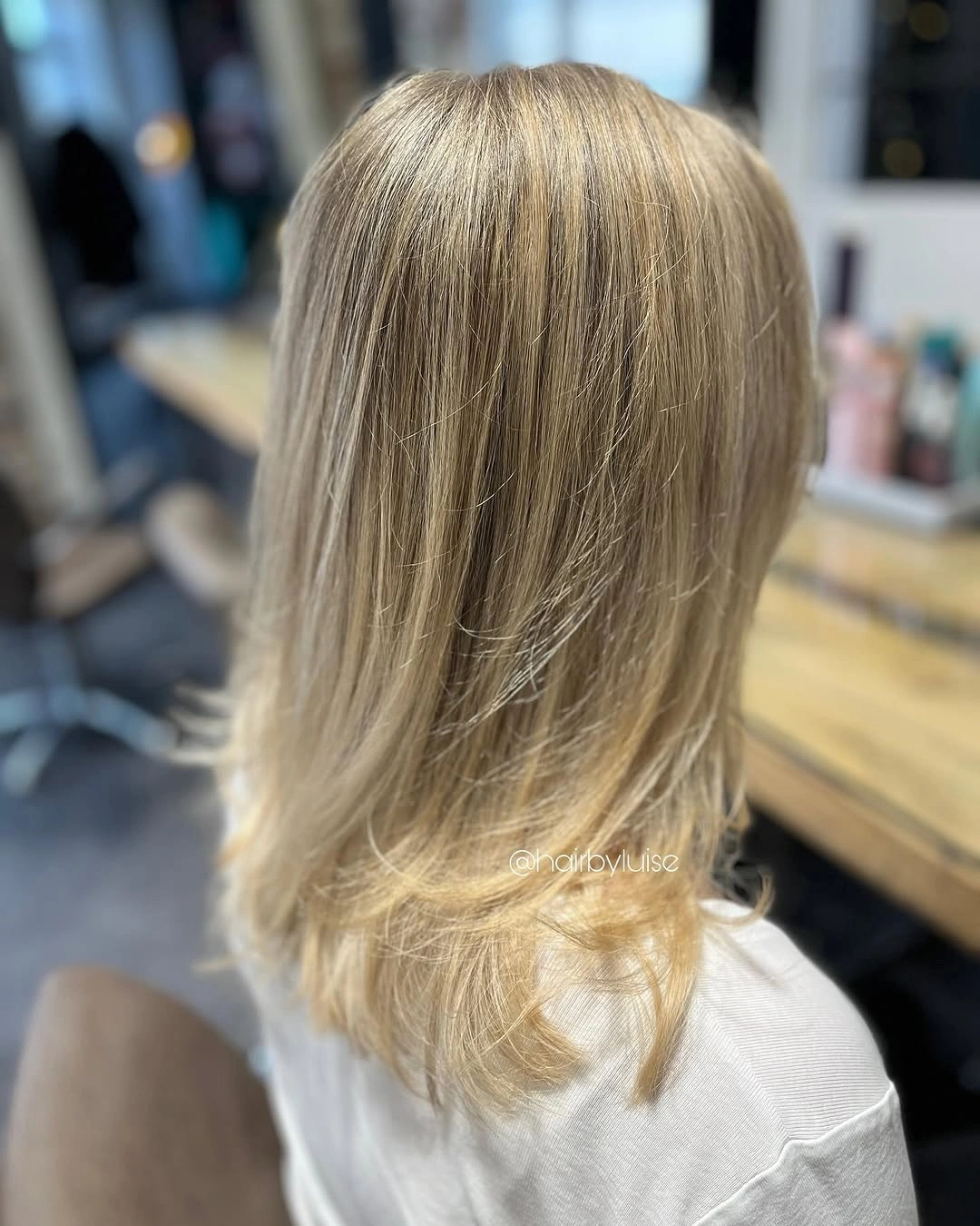 Medium-length golden beige blonde hair with straight upper lengths and curved ends