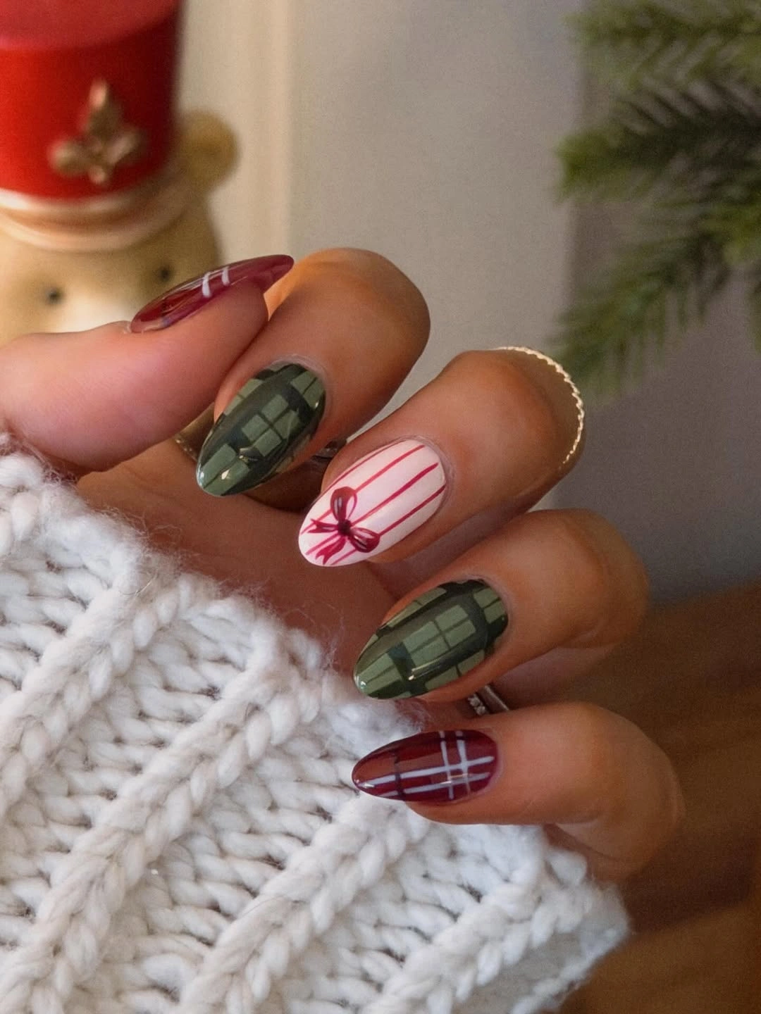 Olive green grid nails with burgundy plaid and a cream bow accent