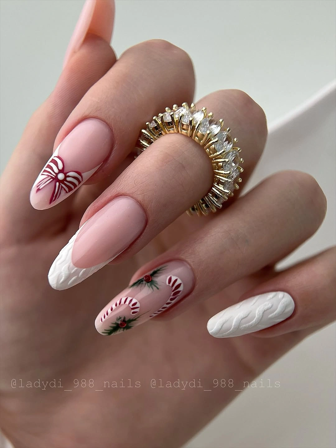 Long pink almond nails with white cable texture and red candy-cane decorations