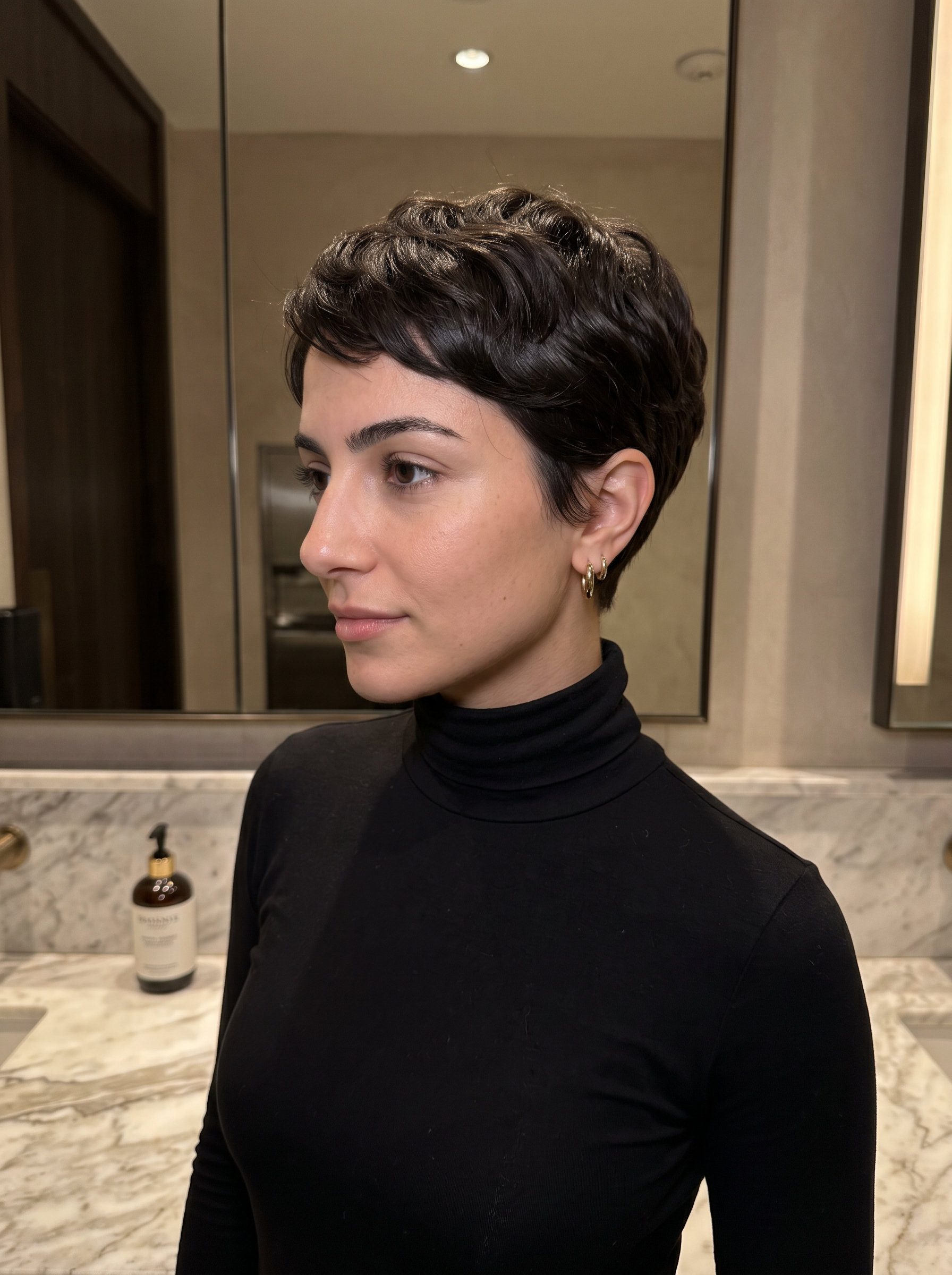 very short pixie haircut with espresso brunette, tapered sides and subtle face-framing for elegance