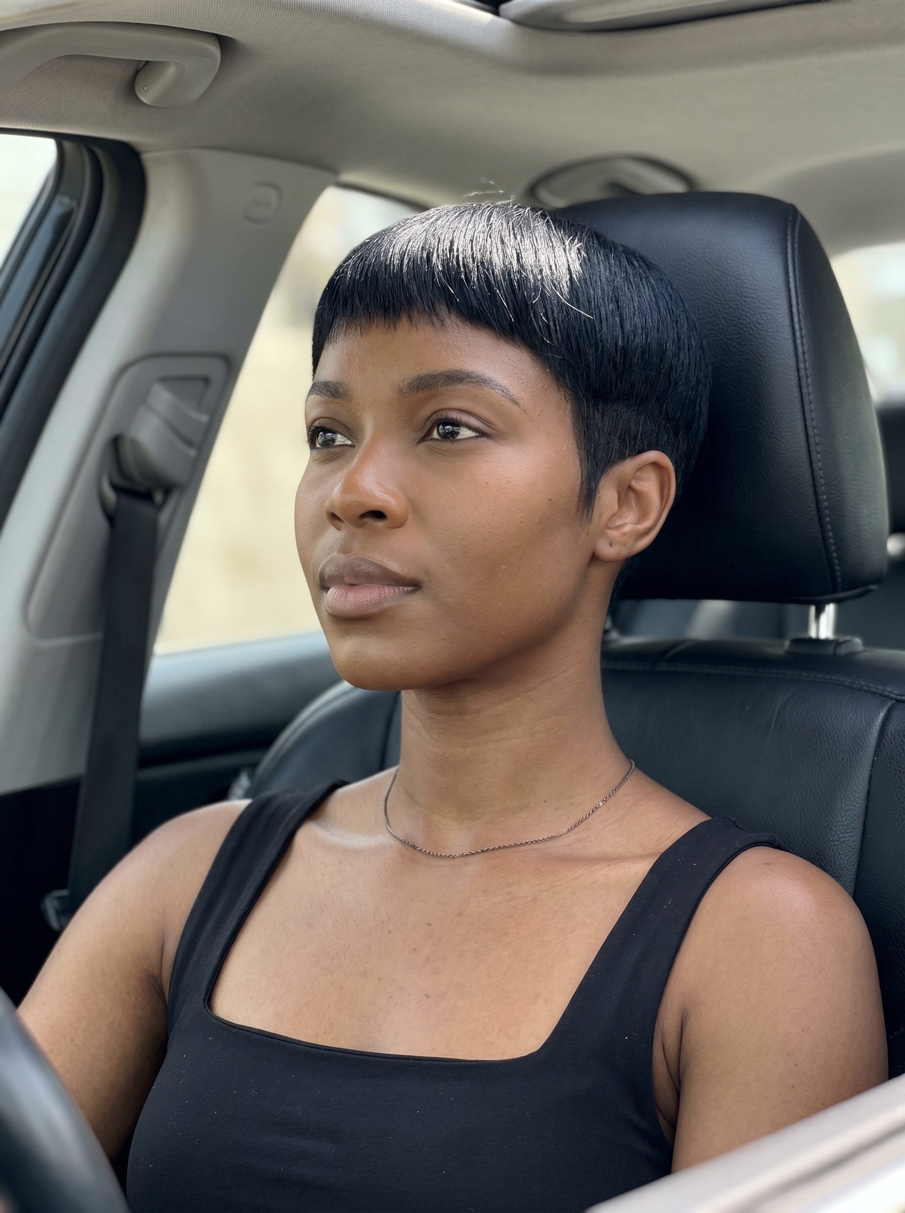 very short pixie haircut in jet black with glass shine, blunt cut — bold formal event