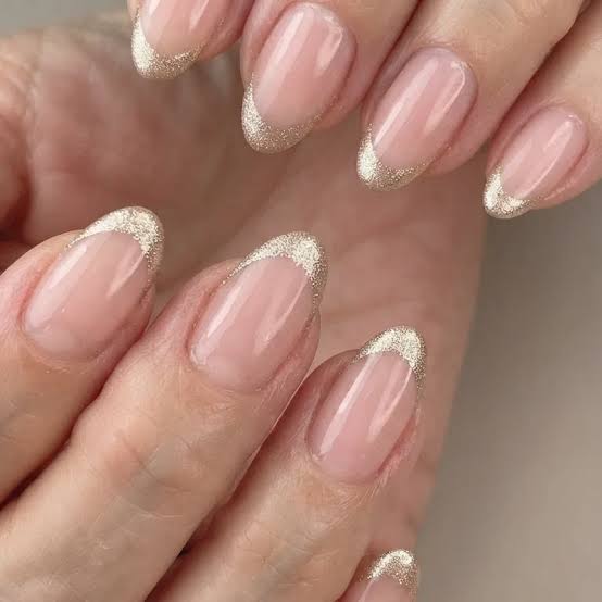 Sheer Nude French Tips with Gold Glitter Oval Nails, Close-Up Take Sheer Nude French Tips with Gold Glitter Oval Nails, Close-Up Take — Simple Champagne Nails