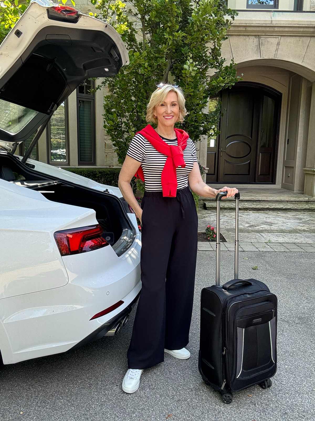 Red Sweater Tied Over Striped Tee and Black Trousers — Simple Road Trip Outfits