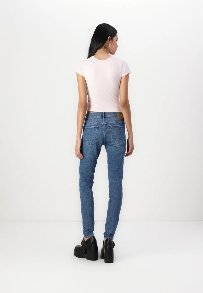 Blue Skinny Jeans with a Light Pink Cropped T-Shirt, Close-Up Take — Simple Skinny Jeans Outfits
