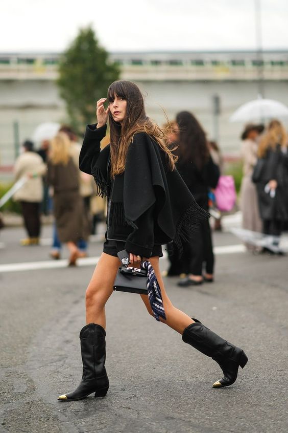 Black Cowboy Boots with a Fringed Cape and Shorts — Trendy Black Cowboy Boots Outfit
