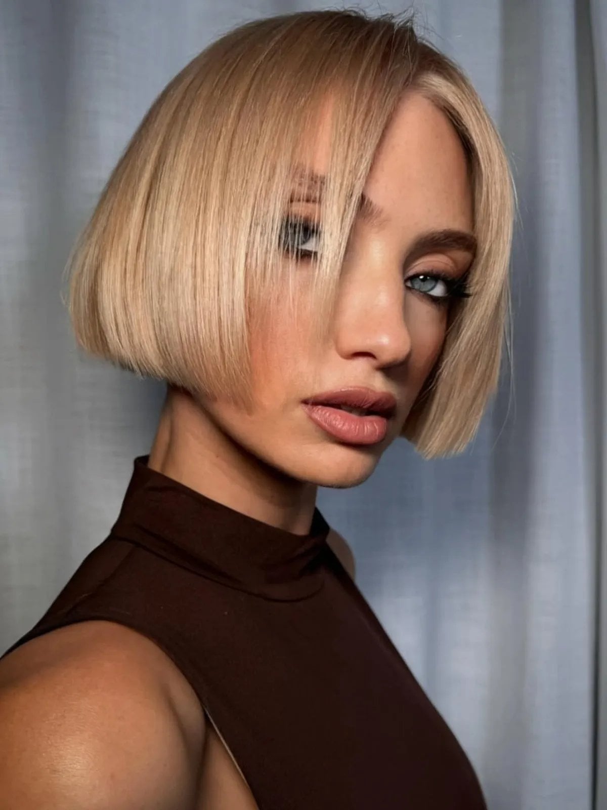 Platinum Bob With Blunt Bangs And Sleek Style — Trendy Blonde Bob