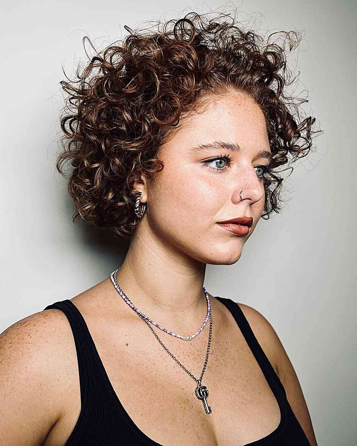 Short Ear Length Bob With Auburn Highlights — Trendy Curly Hair