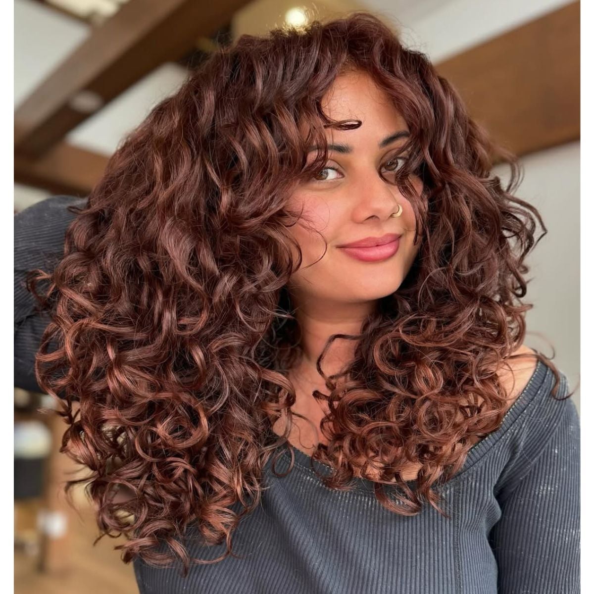 Mid-Back Auburn Layers With Face-Framing Bangs — Trendy Curly Hair