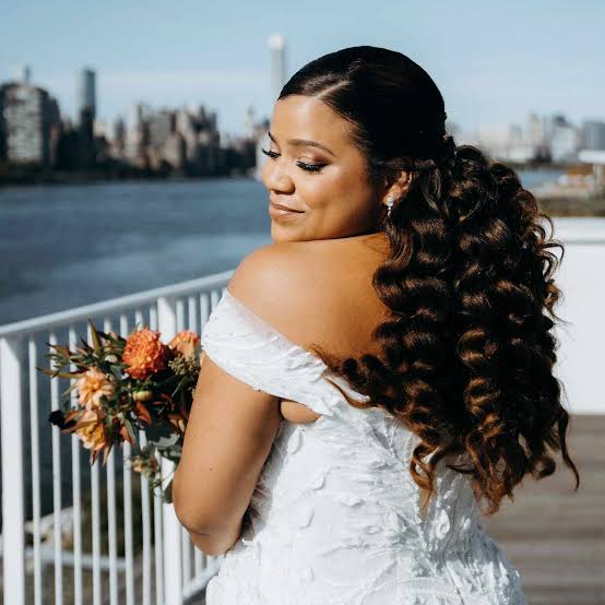 Voluminous Dark Brown Curly Ponytail With Side-Swept Bangs Voluminous Dark Brown Curly Ponytail With Side-Swept Bangs — Trendy Curly Hair Wedding