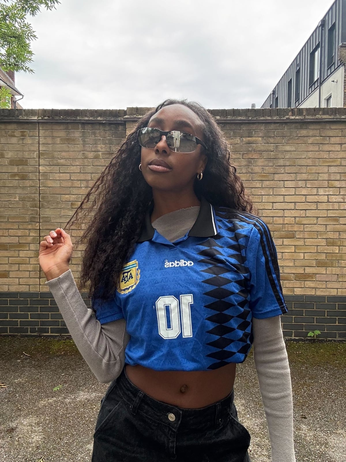 Tied Red Jersey Over White Shirt and Yellow Sneakers, Sunglasses — Trendy Jersey Outfit