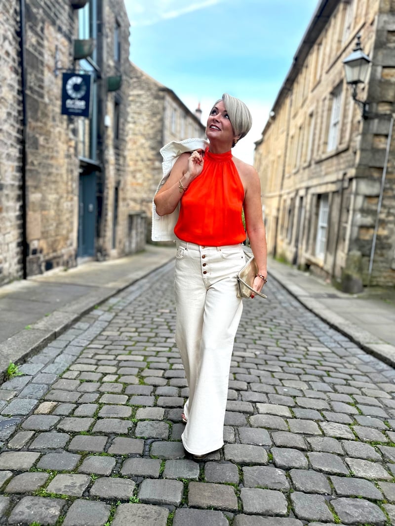 Orange Halter Top with White Jacket and Cream Wide-Leg Trousers — Trendy Monday Outfit