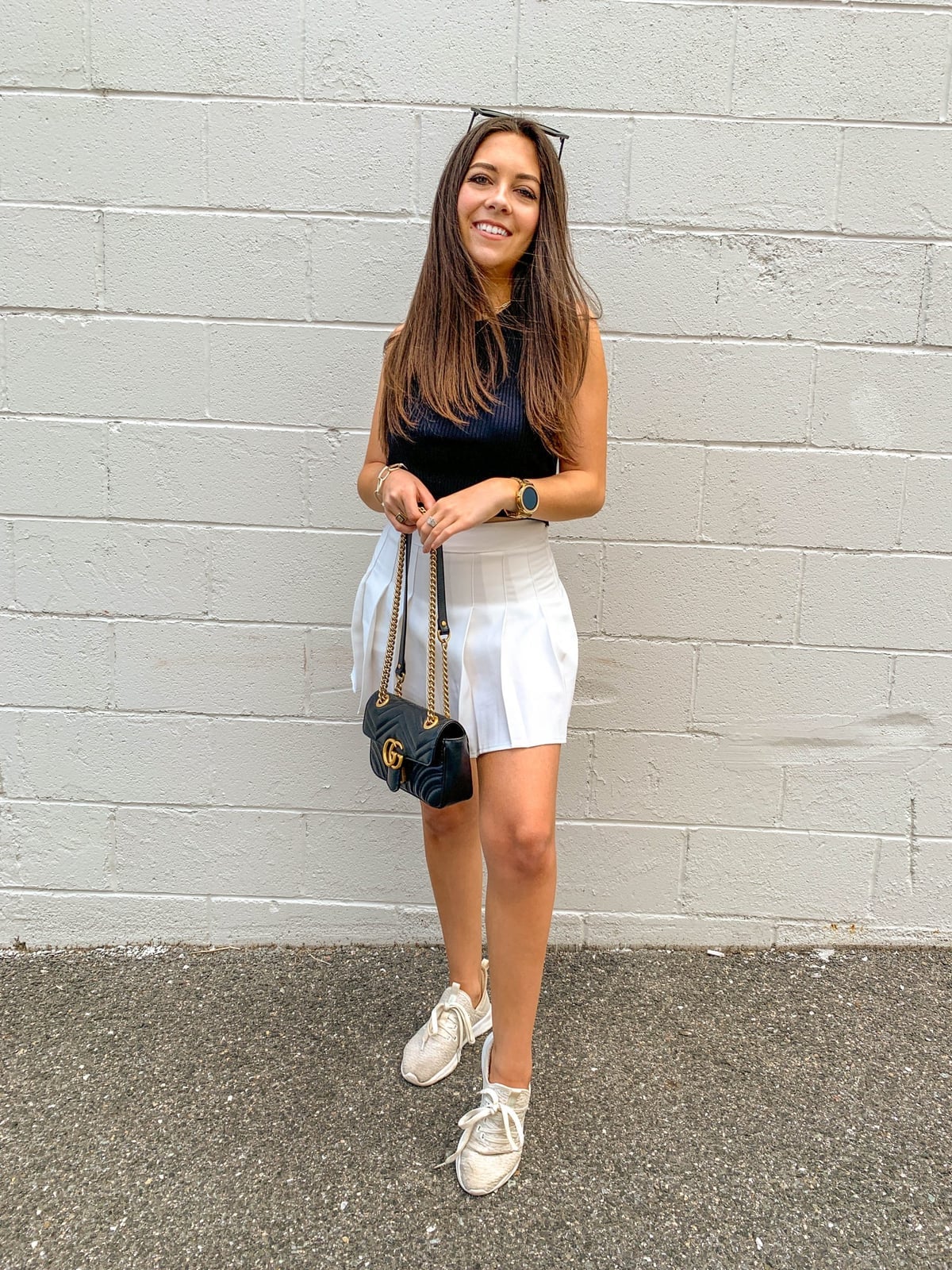 Black Sleeveless Top and White Pleated Mini Skirt With Beige Sneakers — Trendy Tennis Outfits