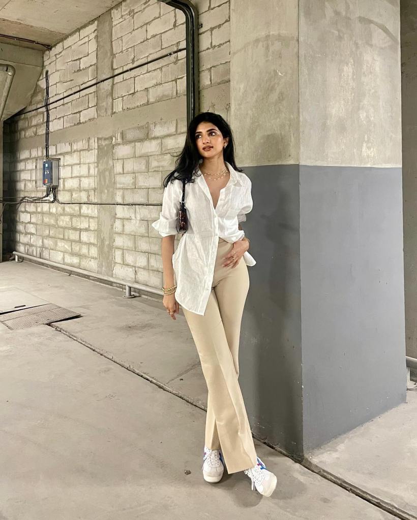 White Oversized Shirt With Asymmetrical Hem And Flared Trousers — Trendy White Shirt Outfits