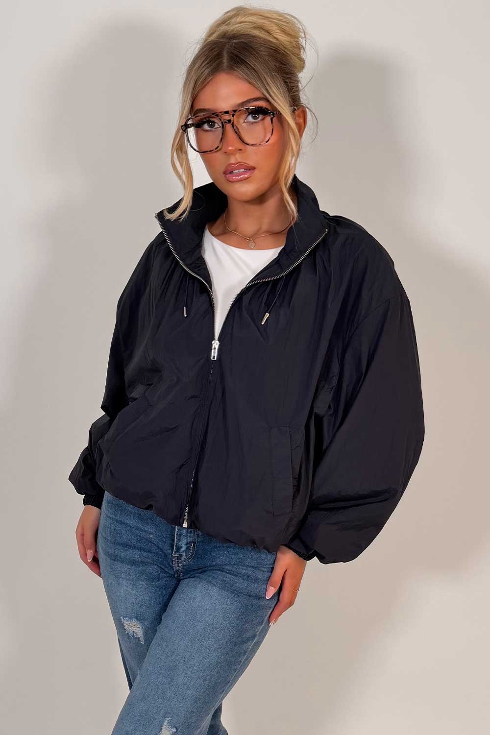 Oversized Black Windbreaker With Denim Jeans and Tortoiseshell Glasses Oversized Black Windbreaker With Denim Jeans and Tortoiseshell Glasses — Trendy Windbreaker Outfits