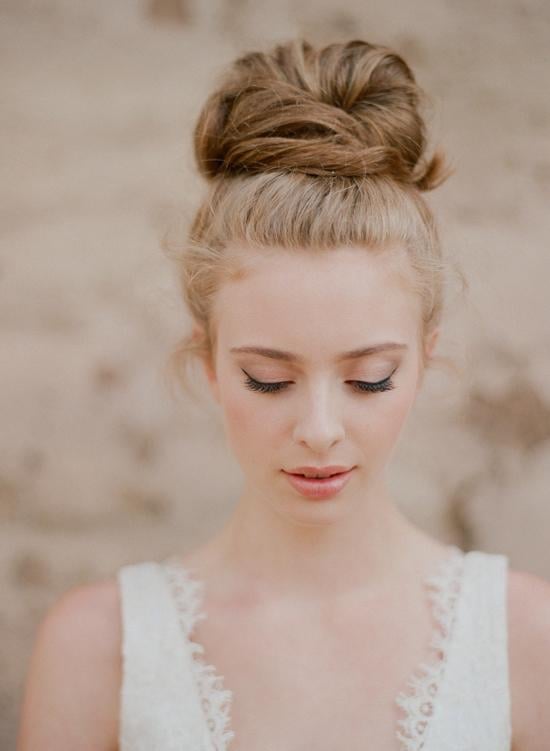 Blonde High Voluminous Bun With Loose Tendrils Blonde High Voluminous Bun With Loose Tendrils — Wedding Bun Ideas