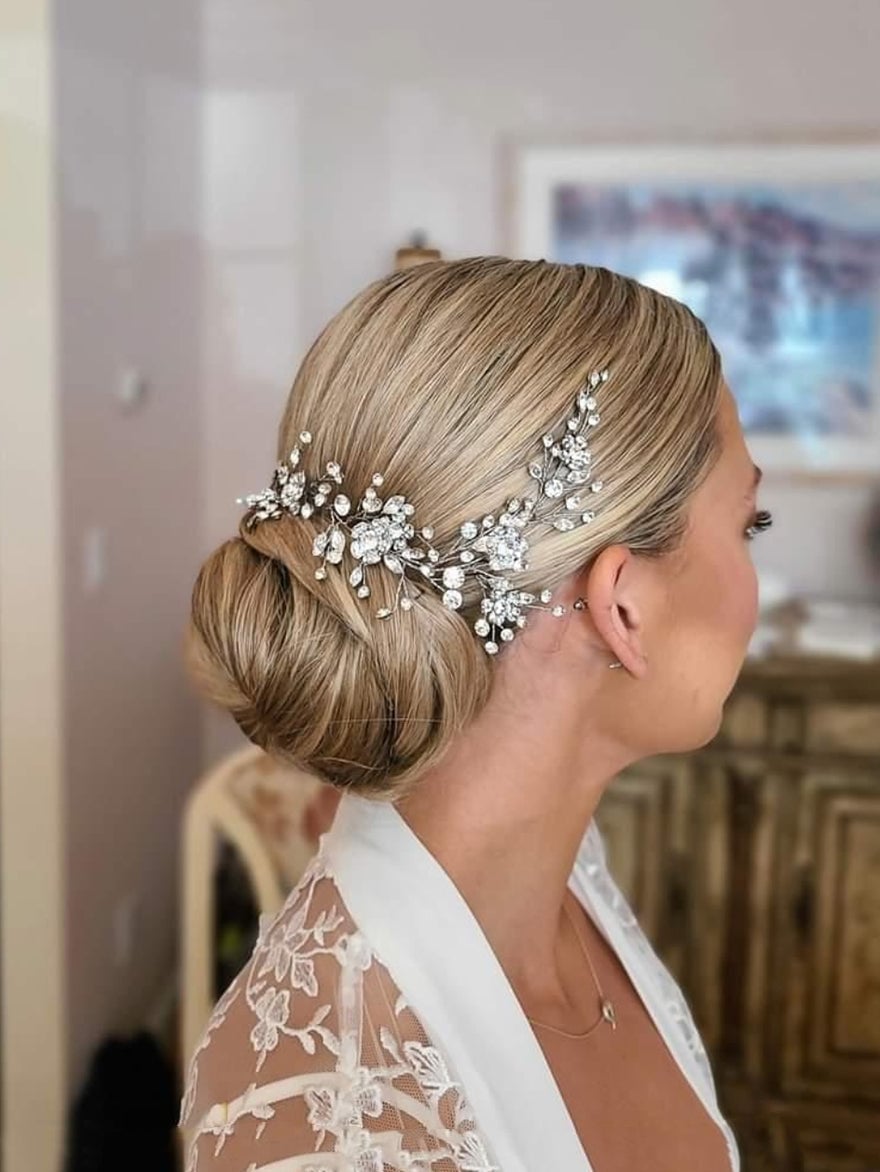 Fine Blonde Sleek Low Bun With Ornate Hairpiece Fine Blonde Sleek Low Bun With Ornate Hairpiece — Wedding Bun Ideas